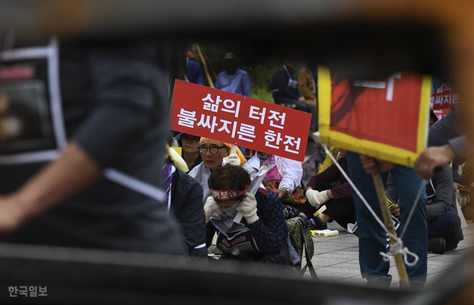 7일 오후 서울 여의도 국회의사당 앞 산불로 타버린 승용차 사이로 보이는 산불 피해자. 홍윤기 인턴기자