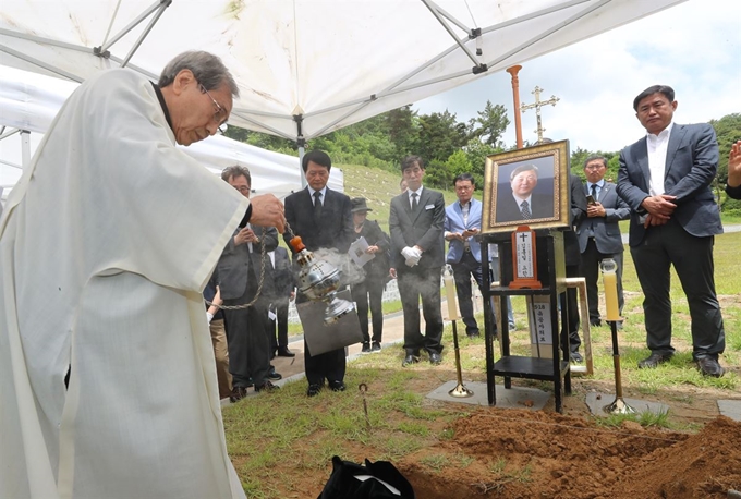 8일 오전 광주 북구 국립5·18민주묘지 제2묘역에서 열린 김대중 전 대통령의 장남 고(故) 김홍일 전 민주당 국회의원 이장 의식을 함세웅 신부가 집전하고 있다. 연합뉴스