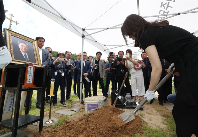 8일 오전 광주 북구 국립5·18민주묘지 제2묘역에서 김대중 전 대통령의 장남 고(故) 김홍일 전 민주당 국회의원의 영현(유골)에 유족이 흙을 뿌리고 있다. 연합뉴스