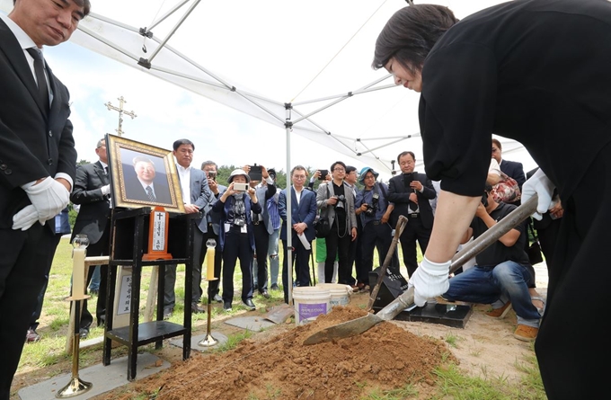 8일 오전 광주 북구 국립5·18민주묘지 제2묘역에서 김대중 전 대통령의 장남 고(故) 김홍일 전 민주당 국회의원의 영현(유골)에 유족이 흙을 뿌리고 있다. 연합뉴스