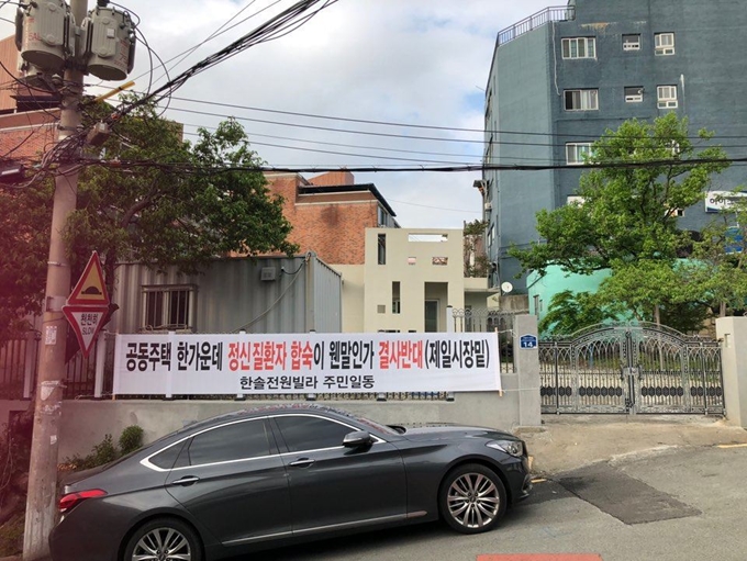 사회복지법인 나눔과행복이 부산 금곡동에 건립한 중증 정신질환자 공동생활가정 건물 앞에 지역주민들의 건립 반대 현수막이 붙어 있다.나눔과행복 제공