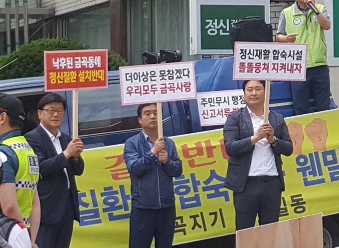 지난달 28일 정신질환을 치료하는 부산시 연제구 나눔과행복병원 앞에 부산시 금곡동 주민들과 부산 시의원 이동호(왼쪽부터) 구의원 김명석, 김성택이 모여 금곡동 중증 정신질환자 공동생활가정 운영을 반대하는 시위를 벌이고 있다. 나눔과행복 제공