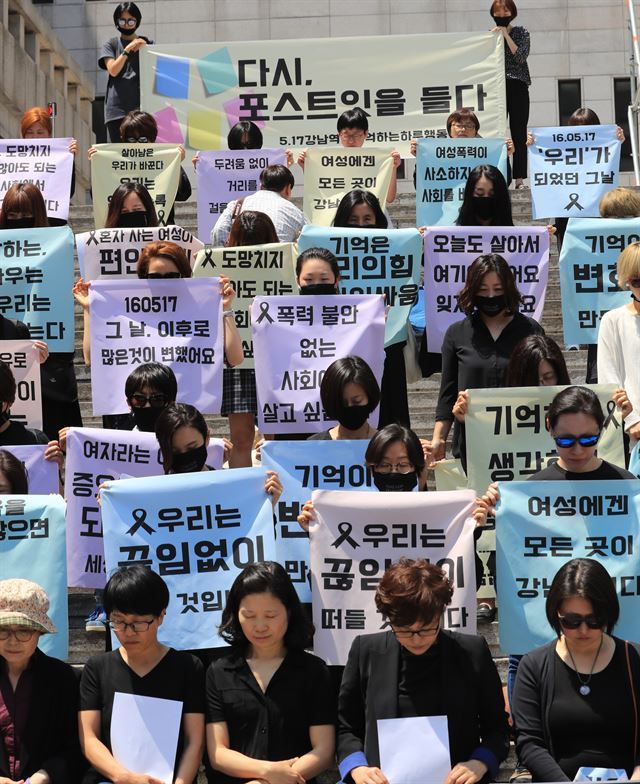 여성인권단체 회원들이 서울 세종문화회관 앞 계단에서 강남역 살인사건 1주기를 맞아 기자회견을 열고 메시지가 적힌 포스트잇을 상징하는 천을 들고 퍼포먼스를 하고 있다. 연합뉴스