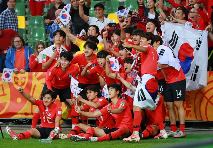 2019 국제축구연맹(FIFA) 20세 이하(U-20) 월드컵 8강 세네갈과의 경기에서 승부차기 접전 끝에 4강 진출을 확정한 대표팀 선수들이 그라운드에 앉아 태극기를 들고 기뻐하며 기념촬영을 하고 있다. 비엘스코비아와(폴란드)=연합뉴스