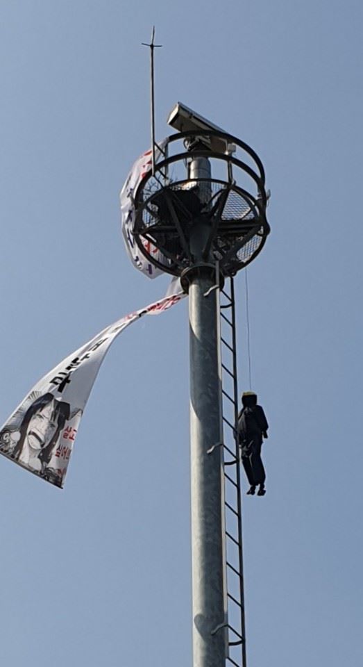 12일 오전 대구 남구 영대병원네거리 교통관제 폐쇄회로TV(CCTV)에 한 남성이 마네킹과 "수술받게 해 달라"는 내용의 현수막을 늘어뜰여 놓은 채 시위를 하고 있다. 독자 제공