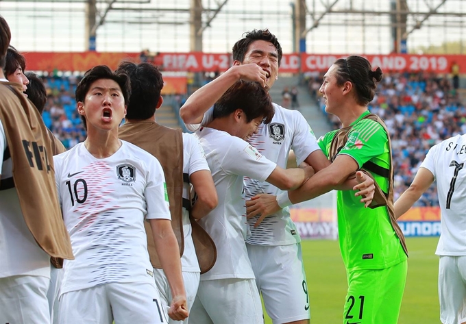 4일 오후(현지시간) 폴란드 루블린 경기장에서 열린 2019 국제축구연맹(FIFA) 20세 이하(U-20) 월드컵 16강 한·일전. 후반 한국 오세훈이 결승 헤더골을 넣은 뒤 어시스트한 최준(가운데 왼쪽), 골키퍼 최민수와 포옹하는 사이 이강인이 관중석을 향해 포효하고 있다. 루블린=연합뉴스