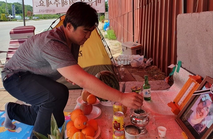 지난달 강원 인제군 서화면에서 발생한 고압전선 가설공사 현장 추락사고로 동생을 잃은 송영준씨가 17일 “안전규정을 충족하지 못한 불량 장비로 인한 사고 원인을 규명해 달라”며 동생이 일하던 춘천시 동면 업체 앞에서 노숙시위를 하고 있다. 박은성 기자