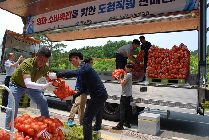 경북도청 직원들이 18일 청사 가온마당에 마련된 양파소비촉진운동에 동참하기 위해 줄지어 양파를 구매하고 있다. 이용호기자