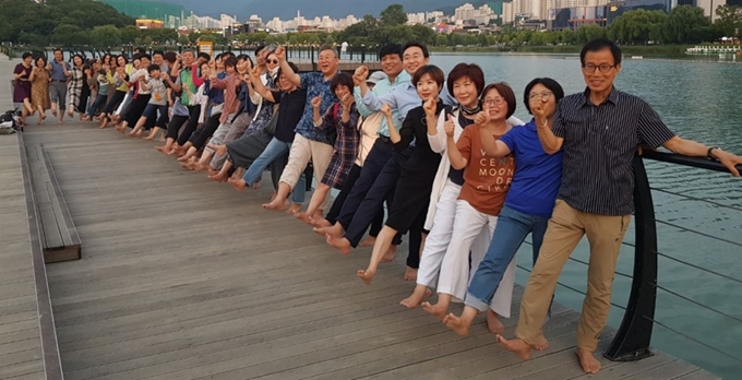 맨발학교 회원들이 17일 수성못에서 맨발걷기를 하기 전 맨발을 크게 들어보이고 있다. 맨발학교 제공