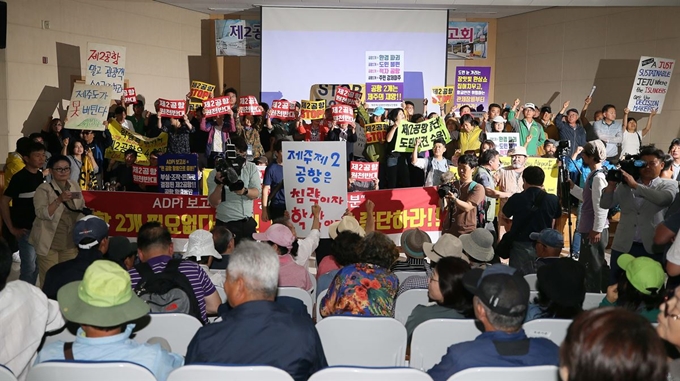 19일 오후 제주 농어업인회관에서 열린 국토교통부 제주 제2공항 기본계획 수립용역 최종보고회에서 반대 단체 등이 단상을 점거하며 항의하고 있다. 연합뉴스.