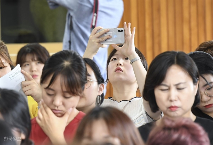 20일 오후 서울 종로구 서울특별시교육청 본관 대강당에서 열린 '2019 학교 밖 청소년 입시 설명회'에서 한 참석자가 자료 화면을 촬영하고 있다. 이한호 기자