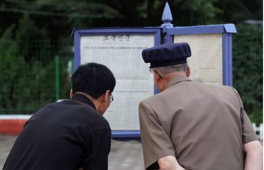 시진핑(習近平) 중국 국가주석의 방북을 하루 앞둔 19일 평양 개선문 인근에서 시민들이 노동신문에 실린 시 주석의 기고문을 읽고 있다. 평양=신화통신 연합뉴스