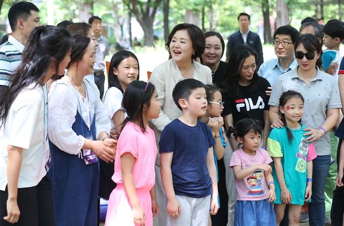 김정숙 여사가 지난 달 서울숲에서 열린 '세상 모든 가족 함께 숲속 나들이' 행사 참가자들과 기념촬영을 하고 있다. 연합뉴스