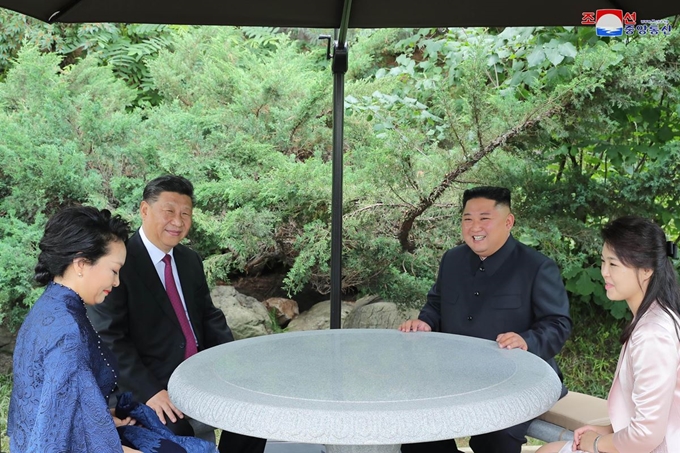 시진핑 중국 국가주석과 부인 펑리위안 여사, 김정은 북한 국무위원장과 리설주 여사가 21일 평양 금수산영빈관에서 산책 도중 자리에 앉아 대화를 나눴다고 조선중앙통신이 22일 보도했다. 평양 조선중앙통신=연합뉴스