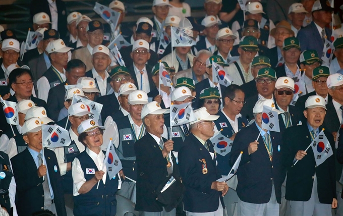 25일 서울 중구 장충체육관에서 열린 6.25 전쟁 69주년 기념 행사에 참석한 6.25 참전 유공자들이 태극기를 흔들며 6.25의 노래를 부르고 있다. 연합뉴스