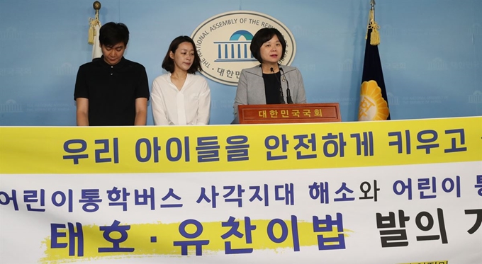 이정미 정의당 의원이 26일 국회 정론관에서 모든 체육시설의 통학차량을 도로교통법 상 어린이 통학차량에 포함시키는 도로교통법 및 체육시설법 일부 개정안(태호ㆍ유찬이법) 발의 기자회견을 하고 있다. 왼쪽부터 지난달 15일 인천 송도에서 발생한 축구클럽 차량 교통사고로 숨진 김태호 군의 부모 김장회, 이소현씨. 연합뉴스