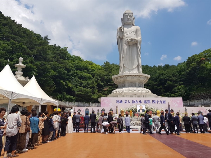 25일 오전 대구 동화사 통일대불전에서 열린 달성 후인 서재승 영가 49재 법회에서 조문객들이 헌화를 하고 있다. 강은주기자 tracy114@hankookilbo.com