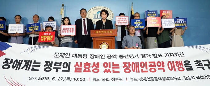 김승희(가운데) 자유한국당 의원과 장애인공동대응네트워크 회원들이 27일 서울 여의도 국회 정론관에서 문재인 대통령 장애인 공약 중간평가 결과 발표 기자회견을 하고 있다. 뉴스1