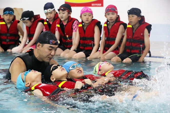 27일 오전 경기도 수원시 장안구 수원도시공사 장안구민회관에서 초등학생들이 여름 휴가철을 앞두고 생존 수영을 배우고 있다. 생존수영은 잎새뜨기, 체온유지법 등으로 구조될 때까지 견디는 물놀이 안전사고 예방법이다. 뉴스1