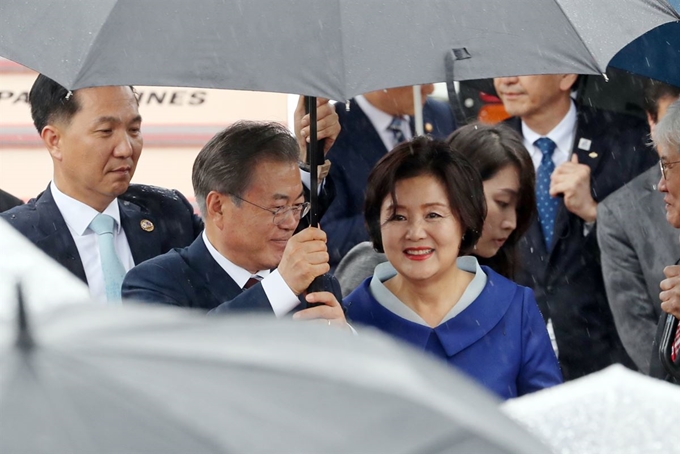 G20 정상회의에 참석차 일본을 방문한 문재인 대통령이 김정숙 여사와 함께 27일 오후 오사카 간사이 국제공항에서 차량으로 이동하던 중 우산을 들어주고 있다. 연합뉴스