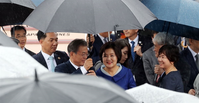 G20 정상회의에 참석하는 문재인 대통령과 김정숙 여사가 27일 오후 오사카 간사이 국제공항에 도착한 공군 1호기에서 차량으로 이동하고 있다. 문 대통령이 우산을 들고 김정숙 여사를 차량으로 안내하고 있다. 연합뉴스