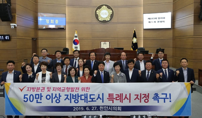 충남 천안시의원들이 27일 본회의장에서 ‘50만 이상 지방 대도시 특례시 지정’ 촉구 결의문 채택하고 기념촬영을 하고 있다. 천안시의회 제공