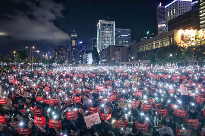 일본 오사카에서 열리는 G20 정상회의 개막을 앞두고 26일(현지시간) 밤 홍콩에서 시위자들이 '홍콩 자유,민주보장'을 주제로 한 시위 중 휴대폰 불빛을 밝히며 구호를 외치고 있다. 일본 오사카에서 열리는 G20 정상회의 개막을 앞두고 시민인권전선 주관으로 열린 야간집회에는 수천명의 시민들이 참석해 범죄인 인도법안 전면 철회, 지난 6월 12일 시위를 폭동 규정 철회와 체포된 모든 시위자들에 대해 무죄 및 경찰들이 경찰의 무력 진압에 대한 독자적인 조사와 캐리 람 홍콩행정관 사임을 요구했다. EPA 연합뉴스