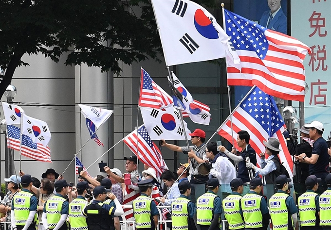 도널드 트럼프 미국 대통령 방한 이틀째인 30일 오전 서울 종로구 세종대로 동화면세점 앞에 모인 우리공화당 등 보수단체 회원들이 트럼프 대통령 차량이 통과하자 성조기를 흔들며 환호하고 있다. 서재훈 기자