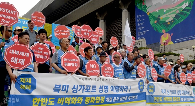 시민단체 평화와 통일을 여는 사람들 관계자들이 30일 서울 세종문화회관 앞에서 트럼프 방한과 관련해 '북미 싱가포르 성명 이행'과 '한반도 비핵화와 평화협정 체결' 동시 실현을 촉구하는 기자회견을 하고 있다. 서재훈 기자