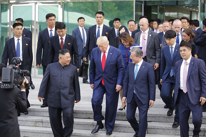 도널드 트럼프(가운데) 미국 대통령, 김정은(왼쪽) 북한 국무위원장이 30일 오후 판문점 남측 자유의 집에서 회담을 마친 뒤 문재인 대통령과 함께 군사분계선으로 이동하고 있다. 연합뉴스