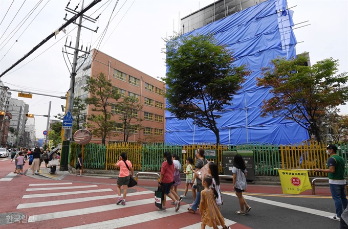 서울 은명초등학교 학생들이 1일 오전 인근 신진과학기술고등학교 체육관에서 방학식을 마치고 마중 나온 학부모와 귀가하고 있다. 홍인기 기자