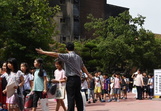 서울 은명초등학교 학생들이 1일 오전 인근 신진과학기술고등학교 체육관에서 방학식을 마치고 교문을 나서고 있다. 홍인기 기자