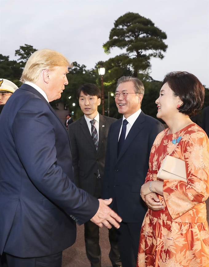 문재인 대통령과 부인 김정숙 여사가 29일 오후 청와대에서 G20 정상회의를 마치고 방한한 도널드 트럼프 미국 대통령을 맞아 반갑게 인사를 나누고 있다. 김 여사 왼쪽 가슴팍 파란 나비 모양 브로치를 두고 민경욱 자유한국당 대변인이 사드 반대 의미를 담았다고 주장했으나 청와대는 이와 무관하다고 반박했다. 연합뉴스