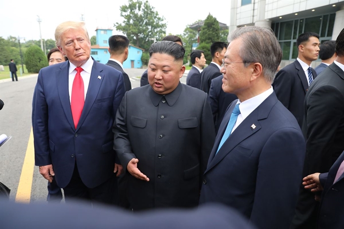 옛 서독은 정권교체와 관계 없이 일관된 통일정책을 폈다. 한국과 미국은 정권이 바뀌면 대북 정책도 오락가락했다. 북한은 70년 넘게 세계 최강대국인 미국과 대결하며 생존의 위협을 느껴온 나라다. 그런 공포심이 북한을 핵개발에 매달리게 만든 원인이다. 두려움과 불신에 젖은 북한에게 정상 간 합의는 반드시 지켜질 것이라는 믿음을 심어주는 게 중요하다. 그러려면 자주 만나서 신뢰를 쌓아야 한다. 사진은 문재인 대통령과 김정은 위원장, 트럼프 대통령이 30일 판문점 공동경비구역(JSA) 자유의 집 앞에서 대화하는 모습. 판문점=류효진 기자