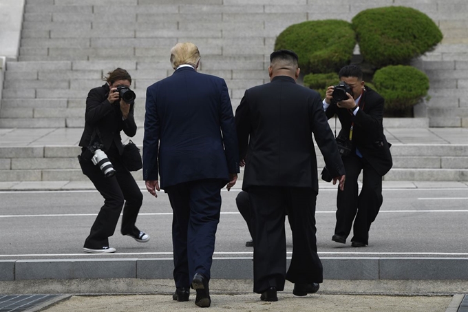 도널드 트럼프 미국 대통령과 김정은 북한 국무위원장이 30일 판문점에서 남북 경계석을 넘어 북한 땅을 걷고 있다. AP 연합뉴스