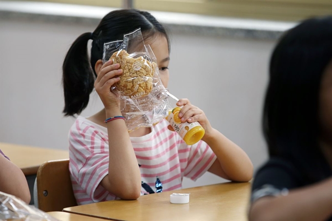 전국 학교 비정규직 연대회의 총파업으로 단체 급식이 중단된 3일 오전 광주 서구 한 초등학교에서 2학년 학생이 대체 급식으로 나눠준 빵과 주스를 먹고 있다. 연합뉴스