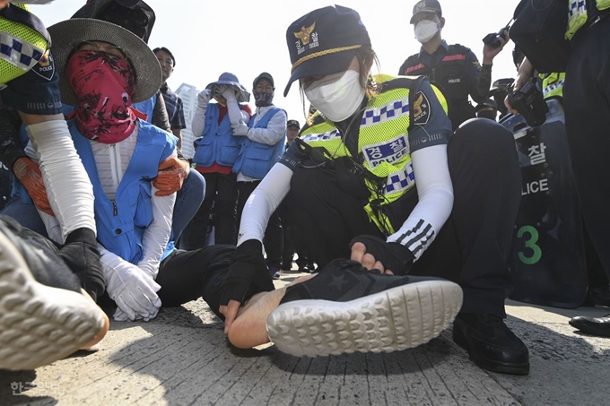 경찰이 농성 참가 인원이 벗어던진 신발을 다시 신기려고 하고 있다. 이한호 기자