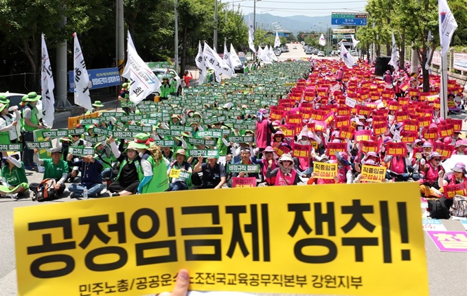 4일 오후 강원 춘천시 강원도교육청에서 열린 총파업 결의대회에서 공공운수노조 교육공무직본부·전국학교비정규직노동조합 강원지부 조합원들이 구호를 외치고 있다. 연합뉴스