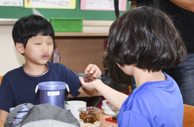 학교 비정규직 노동자들의 파업이 이틀째 접어든 4일 오후 서울의 한 초등학교에서 한 학생이 친구에게 과일을 나눠주고 있다. 이한호 기자