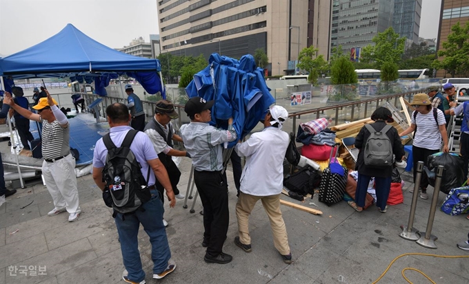 도널드 트럼프 미국 대통령의 방한을 하루 앞둔 지난달 28일 우리공화당 당원들이 서울 광화문광장에 설치된 천막을 파이낸스센터 앞으로 옮기기 위해 철거하고 있다. 서재훈 기자