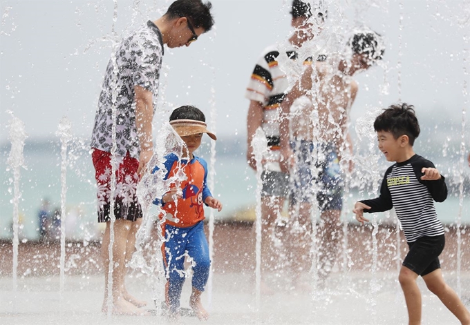 전국적으로 30도 안팎의 기온을 보여 폭염특보가 발효된 5일 제주시 애월읍 곽지과물해변 인근에 조성된 분수대에서 피서객들이 물놀이를 하며 더위를 식히고 있다.뉴스1