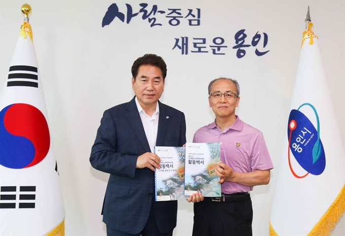 용인시는 지난해 8월 용인지역 난개발 실태조사를 위한 난개발특별위원회를 구성, 10개월동안 활동을 담은 백서를 발간했다. 지난 4일 특위가 제작한 백서를 특위위원이 백군기 용인시장이 전달받고 기념촬영을 하고 있다. 용인시 제공