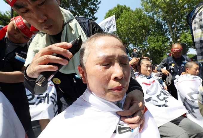 전국집배노동조합원들이 6일 오후 서울 종로구 청와대 사랑채 인근 도로에서 열린 노동조건 개선 촉구 총파업 결의대회에서 삭발식을 하고 있다. 뉴시스