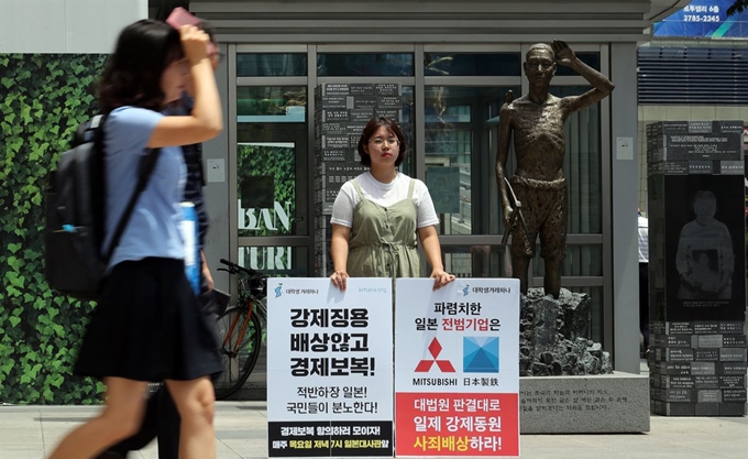 서울겨레하나 회원이 8일 오후 서울 용산구 용산역 앞에 설치된 '강제징용 노동자상' 앞에서 일본의 경제보복을 규탄하는 1인 시위를 하고 있다. 뉴스1