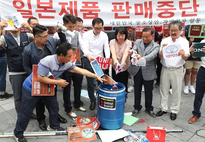 한국중소상인자영업자총연합회 회원들이 15일 서울 종로구 옛 일본대사관 앞에서 열린 일본제품 판매중단 확대선포 기자회견에서 일본업체의 로고를 쓰레기통에 버리는 퍼포먼스를 하고 있다. 이들은 일본의 무역보복을 규탄하며 지난 5일 돌입했던 일본제품 판매중지 돌입 및 불매운동을 전국단위로 확대 전개할 것이라고 밝혔다. 연합뉴스