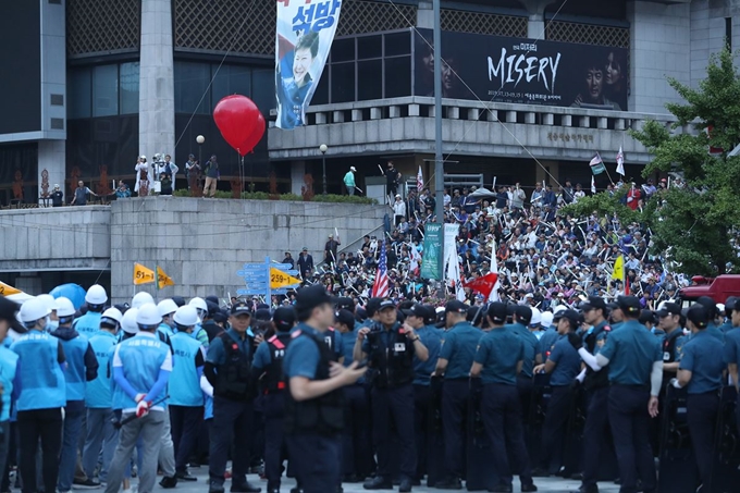 서울 광화문광장에 불법 설치된 우리공화당 천막에 대한 행정대집행이 예정된 16일 새벽 경찰과 서울시 관계자들이 자진 천막 철거 이후 집회에 나선 당 관계자들을 바라보고 있다. 연합뉴스