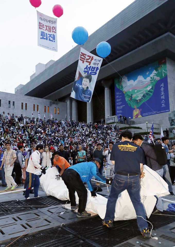 우리공화당 관계자들이 16일 오전 서울 광화문광장 천막을 자진 철거한 뒤 세종문화회관 앞 인도에 설치했던 천막을 다시 자진 철거하고 있다. 뉴시스