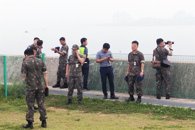 합동참모본부 관계자들이 17일 충남 당진 서해안고속도로 행담도 휴게소 인근에서 "해상에서 잠수함의 잠망경 추정 물체를 봤다"는 신고에 관해 확인 작업을 하고 있다. 연합뉴스