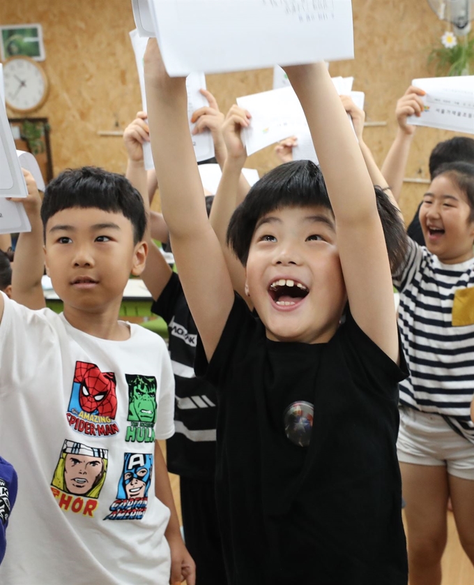 19일 서울 서대문구 가재울초등학교에서 2학년 학생이 자신의 1학기 학교생활 안내문을 들고 뛰고 있다. 연합뉴스