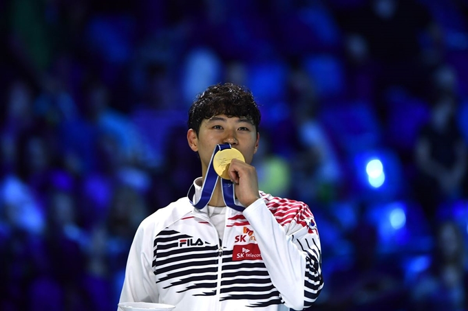 오상욱 선수가 18일(현지시간) 헝가리 부다페스트에서 열린 2019 세계선수권대회 남자 사브르 개인전 결승에서 안드라스 사트마리(헝가리)를 15-12로 역전 우승을 한 후 시상식에서 금메달에 입을 맞추고 있다.MTI, AP 연합뉴스